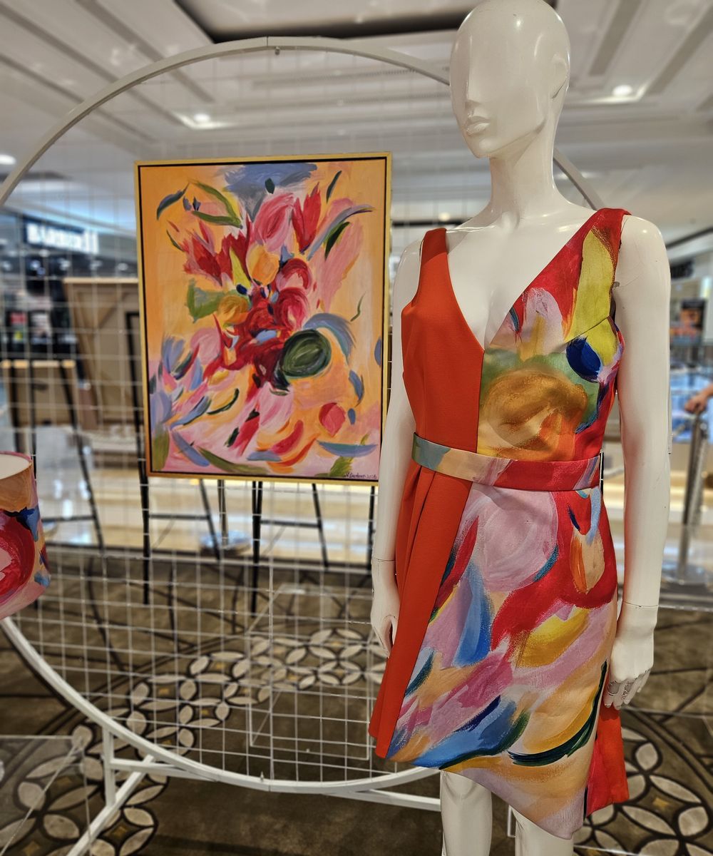 Close view of the Canvas to Couture dress on a mannequin beside the original abstract floral painting that inspired it