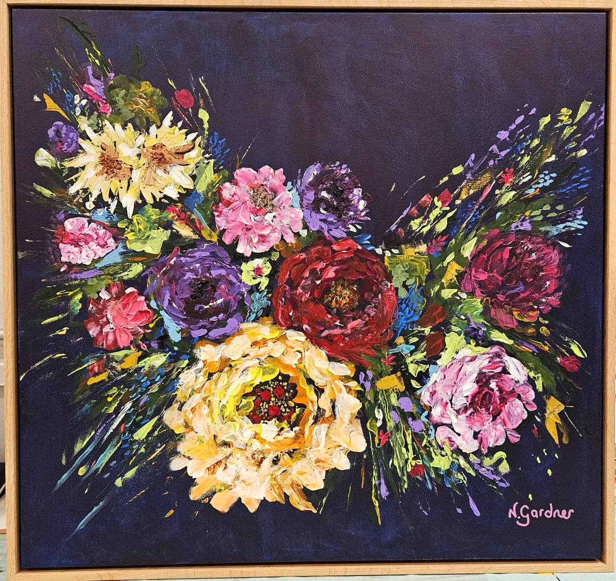 Original painting of a lush floral swag in pinks, purples and yellows on a navy blue background, framed in oak